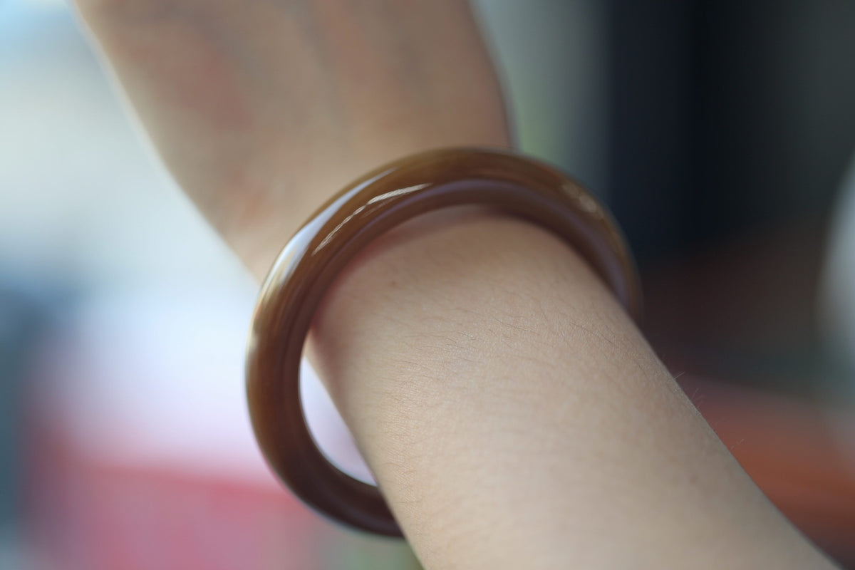 ATELIER 007 · Caramel — nephrite jade bangle, on the wrist