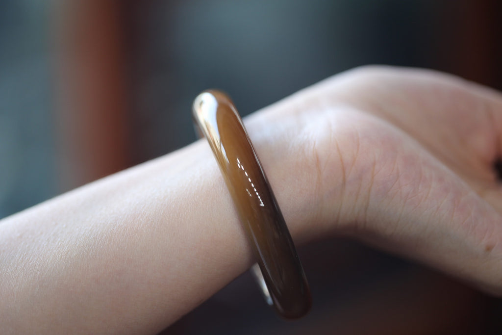 ATELIER 007 · Caramel — nephrite jade bangle, on the model