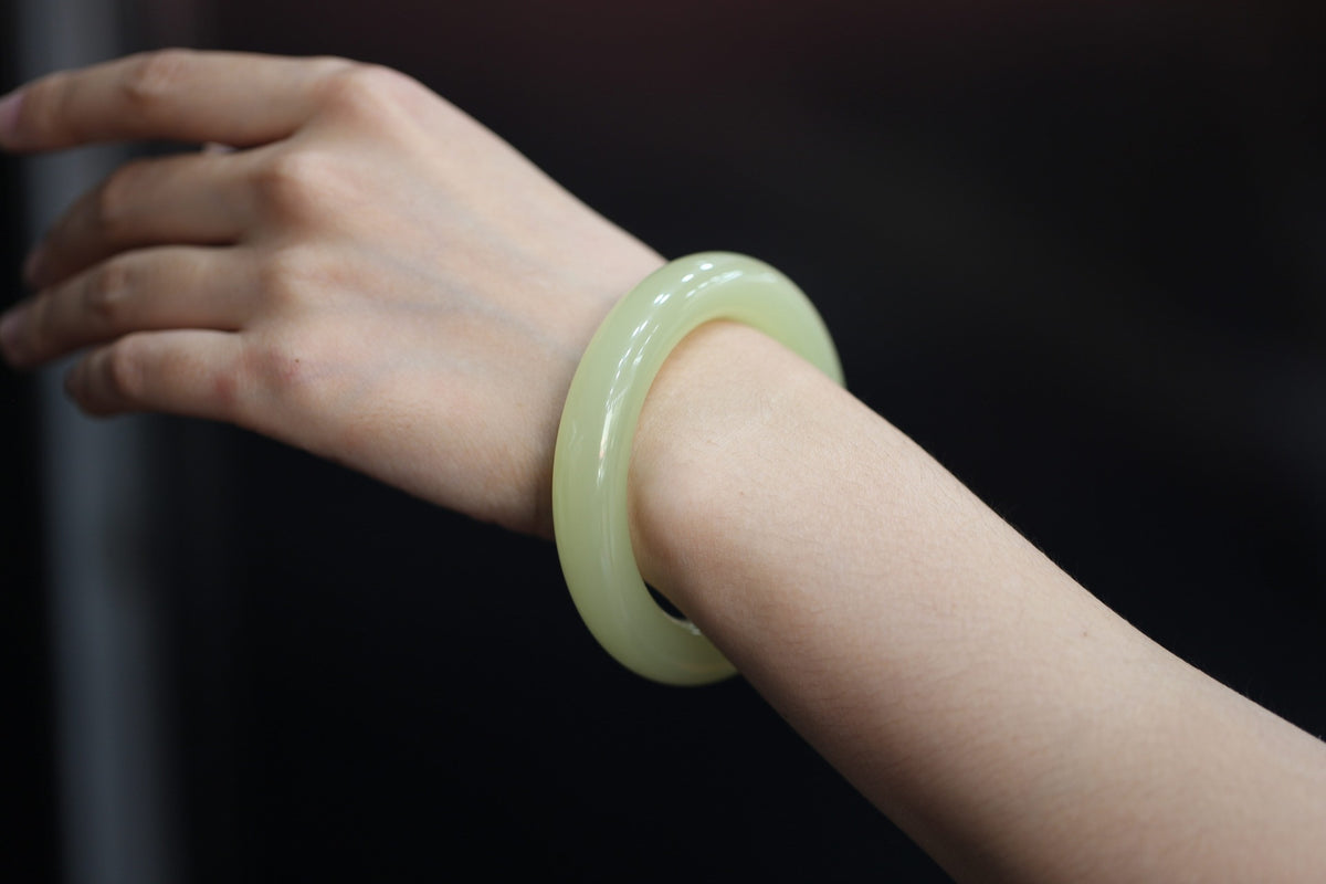 ATELIER 012 · Golden Green — nephrite jade round bangle, on the hand
