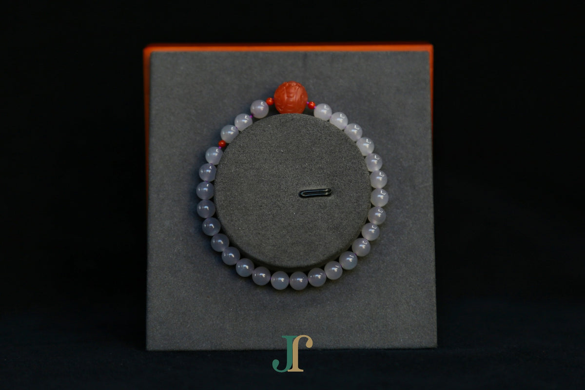GAIA Earthy 6 Spiritual · Smoky Lilac · Carved Round — nephrite jade bead bracelet, on a display stand