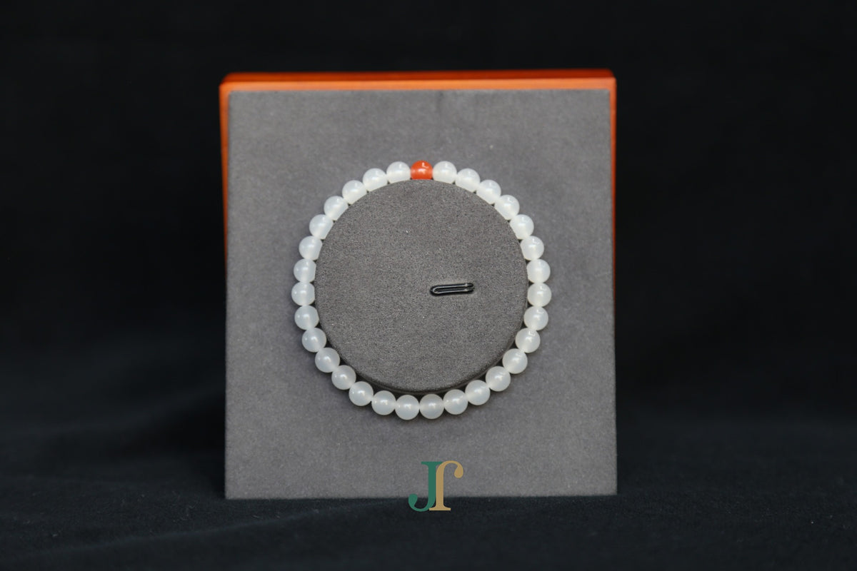 GAIA Earthy 6 Spiritual · Suet White · Red Agate — nephrite jade bead bracelet, on a display stand