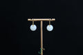 GAIA Luna 14 · Suet White — nephrite jade earrings, on a display stand