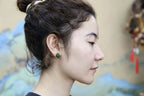 GALET 006 · Willow Green — nephrite jade earrings, on the hand