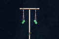 GALET 038 · Willow Green — nephrite jade earrings, on a display stand