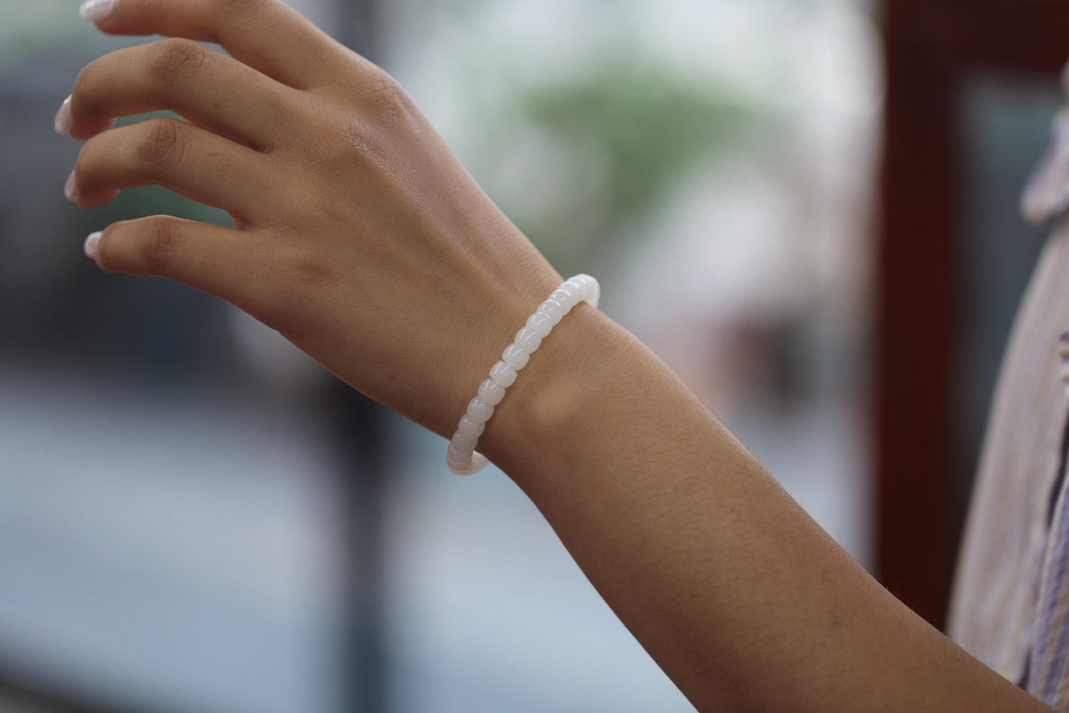 PILLAR Pill 6.7×5 · Suet White 1 — nephrite jade cylinder bracelet, on the hand