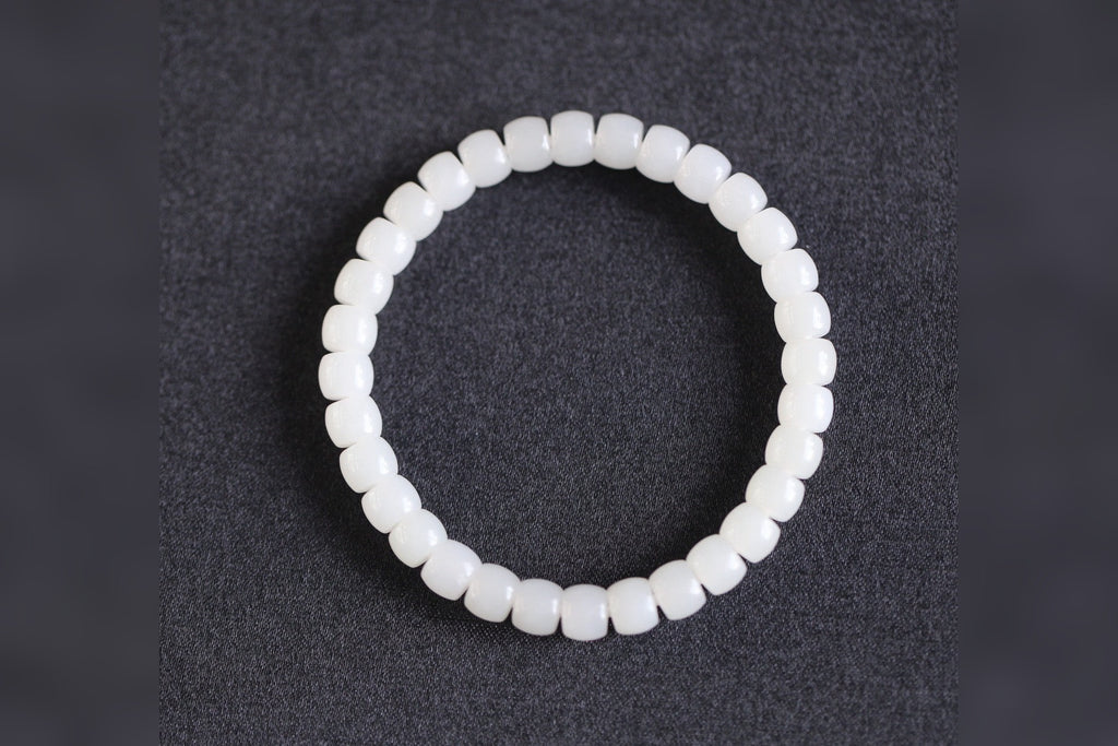 PILLAR Pill 6.7×5 · Suet White 1 — nephrite jade cylinder bracelet, on the model