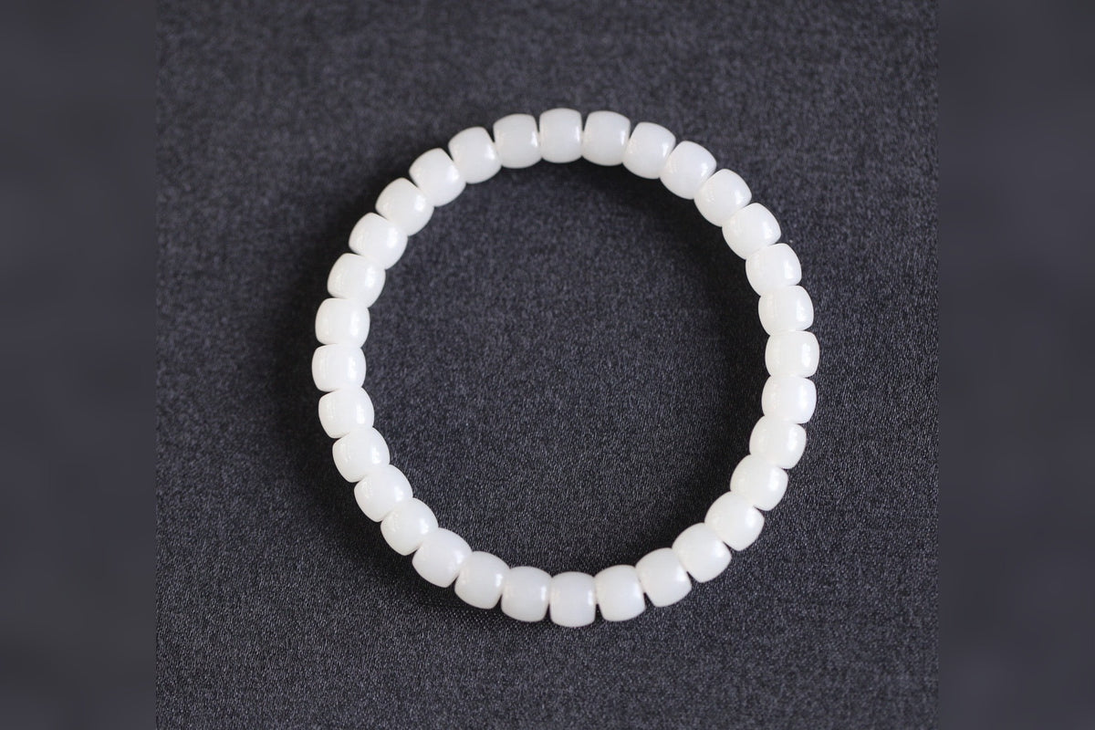 PILLAR Pill 6.7×5 · Suet White 1 — nephrite jade cylinder bracelet, on the model