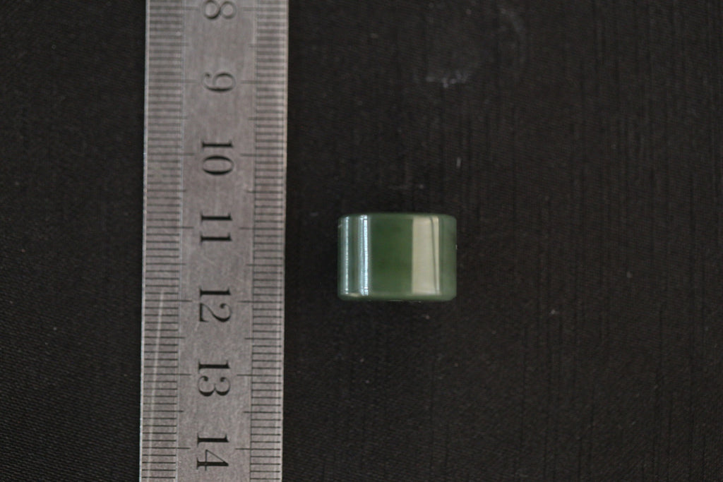 PILLAR Pure 16×11.2 · Spinach Green — nephrite jade pendant, with a ruler for scale