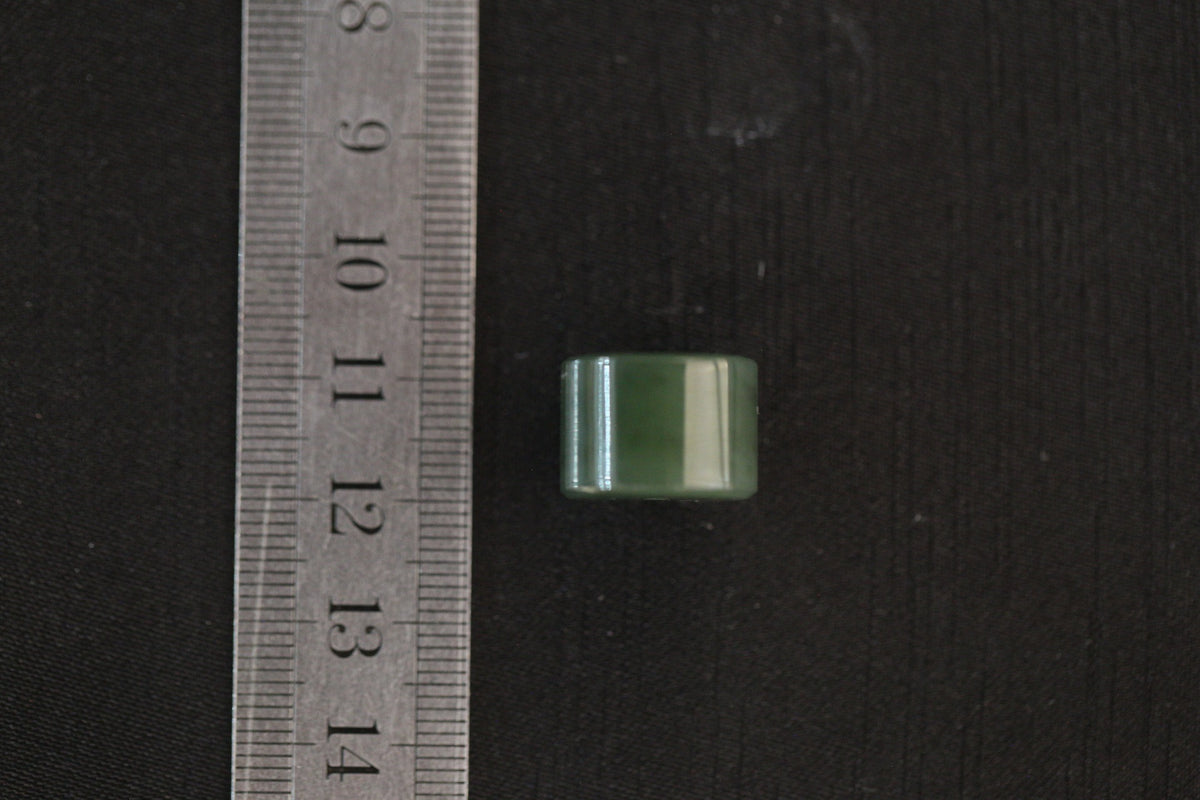 PILLAR Pure 16×11.2 · Spinach Green — nephrite jade pendant, with a ruler for scale