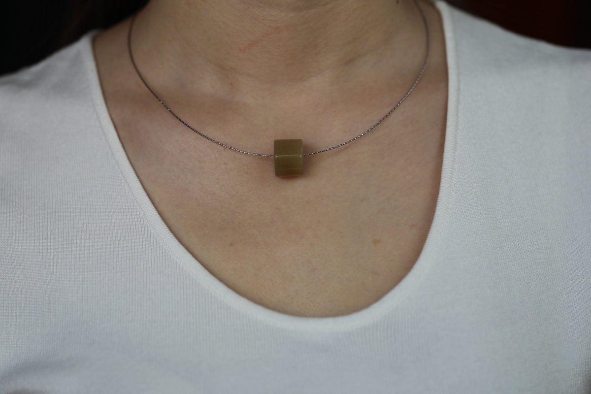 PILLAR Pure 16×12 · Multi-Colour — nephrite jade pendant, worn, close-up