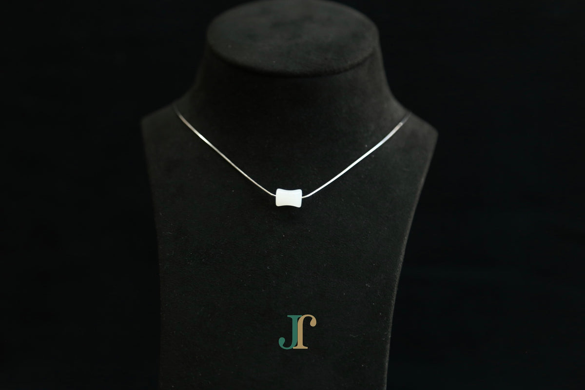 PILLAR Pure 6×12 · Suet White — nephrite jade cylinder necklace, on a display bust