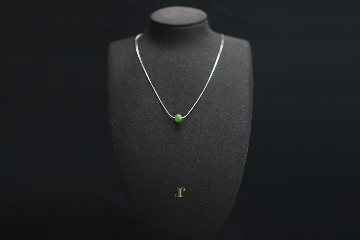 PILLAR Pure 7×6 · Spinach Green — nephrite jade cylinder necklace, on a display bust