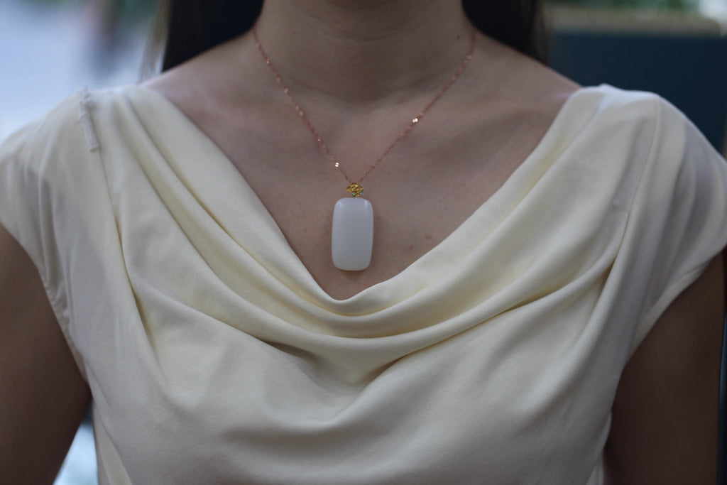 TABULA 002 · Suet White — nephrite jade pendant, on the hand