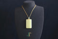 TABULA 017 · Golden Green — nephrite jade pendant, on a display bust