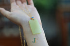 TABULA 017 · Golden Green — nephrite jade pendant, in the hand, second view